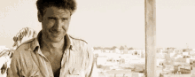a man in a white shirt is smiling in a black and white photo