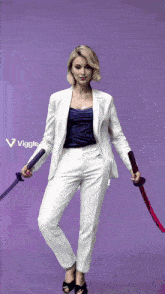 a woman in a white suit holds two swords in front of a purple background