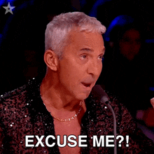 a man is speaking into a microphone and says excuse me ?