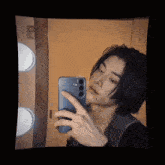 a young man taking a picture of himself in the mirror