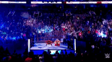 a man and a woman are standing in a wrestling ring with their arms outstretched .