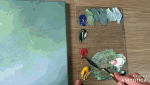 a person is mixing paint on a palette that says made in animotica on it