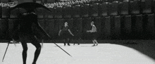 a black and white photo of a man holding a sword in front of a crowd