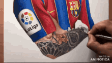 a person is drawing a soccer player 's arm with a laliga patch on it