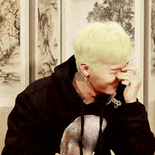 a man with a ring on his finger is covering his nose with his hand