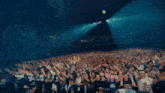 a man in a white shirt is standing in front of a crowd with his arm in the air