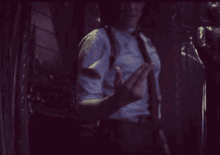 a man in a suit and tie is giving the middle finger in a dark room