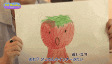 a person holds up a drawing of an octopus with a green leaf on its head