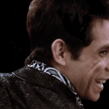 a close up of a man 's face with a black background smiling