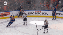 a hockey game is being played in front of an ad for kfc kfc kfc