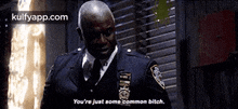 a man in a police uniform is talking to another man in a dark room .