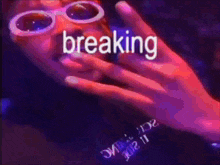 a person wearing sunglasses is covering their mouth with their hand while the word breaking is written above them