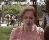 a woman in a pink shirt is holding a book in her hand and says `` and now i have all these ... ''