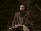 a man with a beard is talking about voices that come through a window