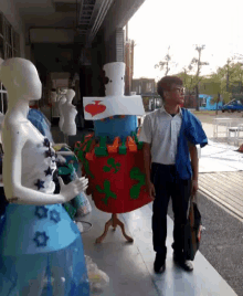 a man is standing next to a mannequin wearing a dress with a heart on it