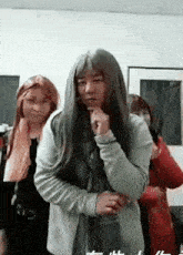 a man with long hair is standing next to a woman with long hair .