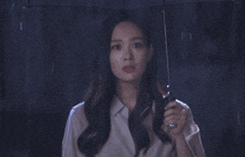 a woman holding an umbrella in the rain with a surprised look on her face