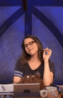 a woman wearing glasses is smiling while holding her hair