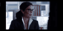 a woman wearing glasses and a suit is talking to another woman .