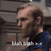 a close up of a man 's face with the words blah blah > . < on the bottom