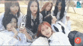 a group of young women are sitting next to each other on a blanket .