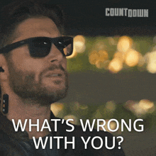 a man wearing sunglasses and earbuds says what 's wrong with you