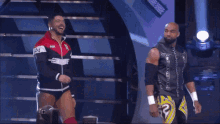 two wrestlers on a stage with one wearing a jacket that says " paul "