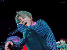 a close up of a person singing into a microphone with promise written on the bottom right