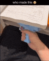 a person is holding a toy gun in front of a piece of paper with a triangle on it and the caption who made this