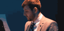 a man in a suit and tie looking down