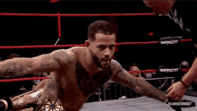 a man in a wrestling ring with a tattoo on his chest