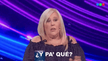 a woman is sitting on a stage with a purple background and asking a question .