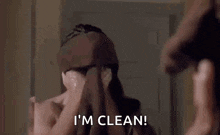 a man is standing in front of a mirror with a towel around his neck and says `` i 'm clean '' .