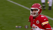 a football player wearing a red helmet with the word touch down behind him