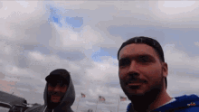 two men are standing next to each other in front of flags