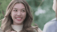 a woman with long hair is smiling and looking up at another woman .
