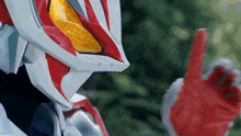 a close up of a robot 's face with a red finger pointing up .
