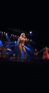 a woman singing into a microphone on stage