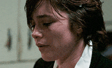 a close up of a woman 's face with a tear coming out of her eye