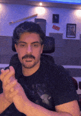a man wearing a black shirt that says mickey mouse applauds