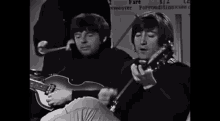 two men are playing guitars and smiling in front of a sign that says fare 1/2