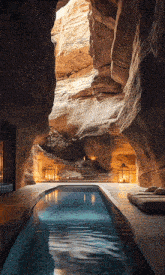 a large swimming pool is surrounded by rocks and candles