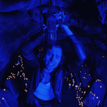 a man in a blue jacket is holding a microphone