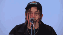 a man singing into a microphone with a hat that says gucci