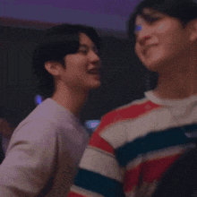 a man is kissing another man on the cheek .