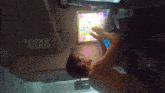 a man is playing a game on a tablet with a pink screen
