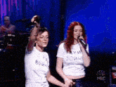 two women wearing white shirts with the word война on them