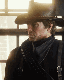 a man wearing a cowboy hat has a belt around his waist with the letter e on it