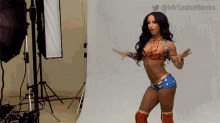 a woman in a wonder woman costume is standing in front of a white wall .