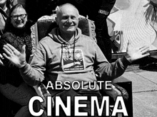 a man wearing a sweatshirt that says " absolute cinema " on it